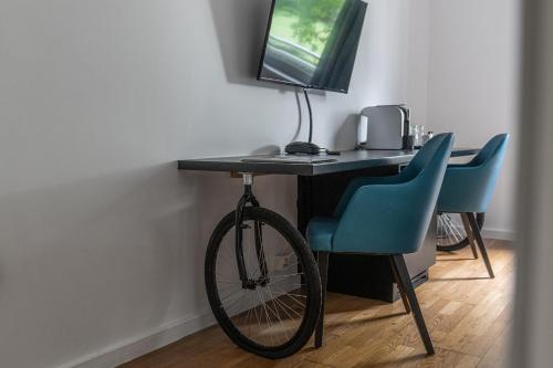 a bike parked next to a desk with a computer at Velotel Brugge in Bruges