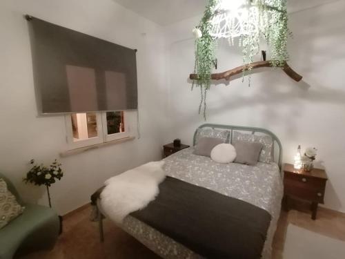 een slaapkamer met een bed en een kroonluchter bij H2A in Aroeira
