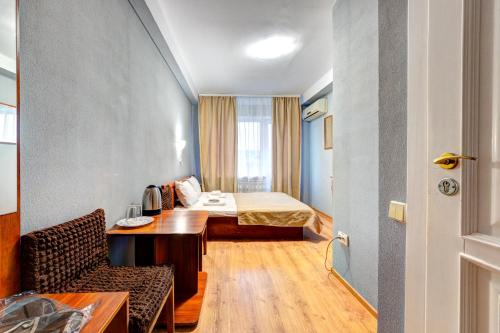 Zimmer mit einem Bett, einem Tisch und einem Stuhl in der Unterkunft Hotel 7F in Kiew