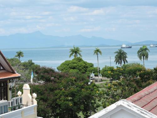 a view of the ocean from the balcony of a house at Merlin Hotel Penang in George Town
