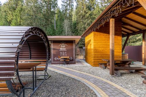 a wooden pavilion with a bench and a table at Arnika Hotel in Bukovel