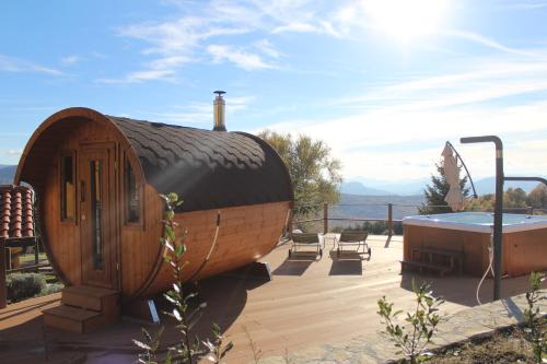 a circular wooden house with a tub on a deck at Masseria Monte Pizzi in Carovilli