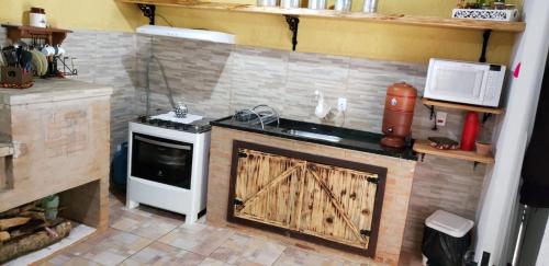 uma cozinha com um fogão e um fogão forno superior em Casa Grande da Montanha - Sítio Pasangas em Santo Antônio do Pinhal