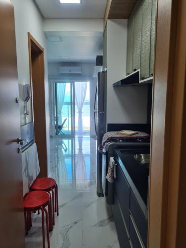 a small kitchen with red stools in a room at Studio Frente para o Mar - Matinhos in Matinhos