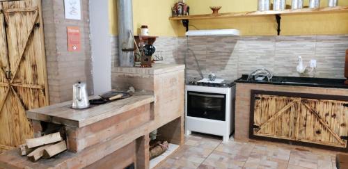 uma cozinha com um fogão e um fogão forno superior em Casa Grande da Montanha - Sítio Pasangas em Santo Antônio do Pinhal