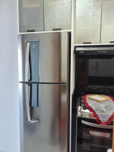 a stainless steel refrigerator in a kitchen next to an oven at Studio Frente para o Mar - Matinhos in Matinhos