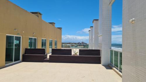a balcony with benches and a view of the ocean at Studio Frente para o Mar - Matinhos in Matinhos