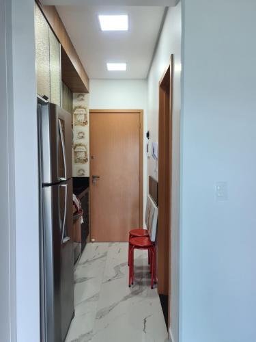 a hallway with a refrigerator and a red stool at Studio Frente para o Mar - Matinhos in Matinhos