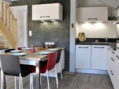 une cuisine avec une table en bois et des chaises rouges dans l'établissement Studio mezzanine renouvé 6 pers, proche commodités et téléski, avec balcon sud/est et casier à ski - FR-1-330-506, à Risoul