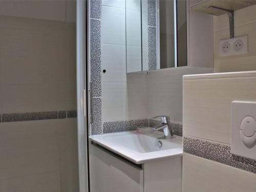 uma casa de banho branca com um lavatório e um espelho em Appartement Risoul, 1 pièce, 6 personnes - FR-1-330-506 em Risoul