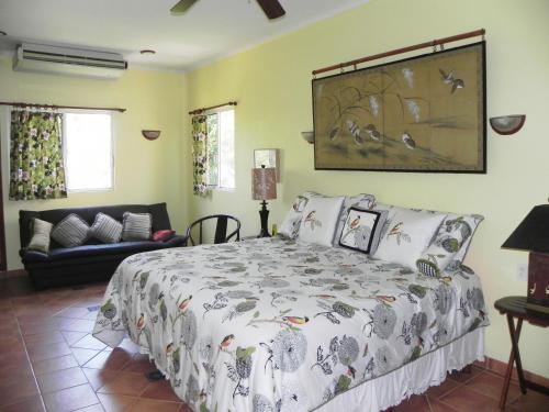 a bedroom with a bed and a couch at Casa Gatos in Akumal
