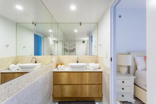 a bathroom with two sinks and a large mirror at Oceanfront Family Apartment Pool & BBQ in Gold Coast