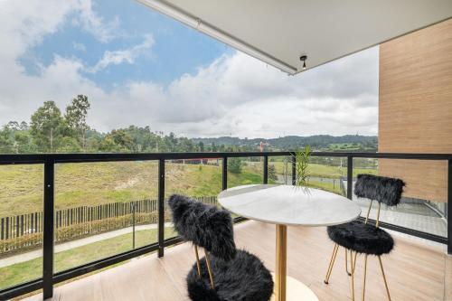 a room with a balcony with a table and two chairs at Olive Living Suites by HOUSY HOST in Envigado