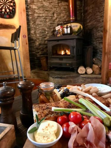 a table with a bunch of food on it with a fireplace at La Vieille Forge B&B in Houffalize