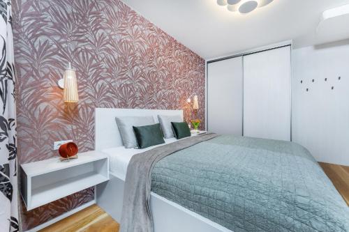 a bedroom with a large bed and a red wall at Apartament I313 Molo Lipno with private wellness in Lipno nad Vltavou