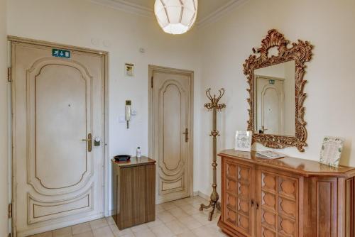 uma casa de banho com um espelho e uma cómoda em madeira em Bramante House - Intero Trilocale vicino alla Metro em Turim