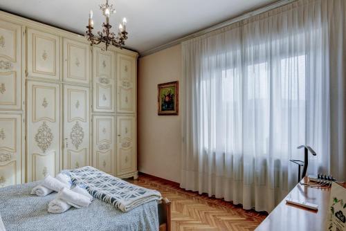 a bedroom with a bed and a large window at Bramante House - Intero Trilocale vicino alla Metro in Turin