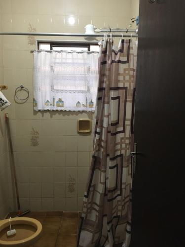 a bathroom with a shower curtain and a toilet at Chalés Maluí Ubatuba in Ubatuba