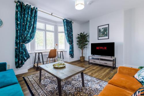 a living room with a couch and a tv at Westwood Lodge Serviced Apartment in Coventry