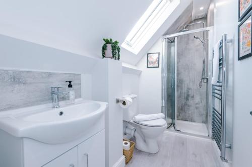 a white bathroom with a sink and a shower at Westwood Lodge Serviced Apartment in Coventry