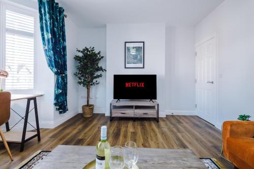 a living room with a tv and a table at Westwood Lodge Serviced Apartment in Coventry