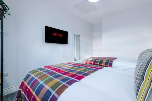 a bedroom with a bed with a clock on the wall at Westwood Lodge Serviced Apartment in Coventry