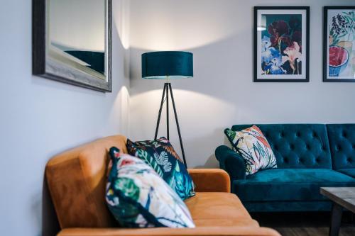a living room with a couch and a lamp at Westwood Lodge Serviced Apartment in Coventry