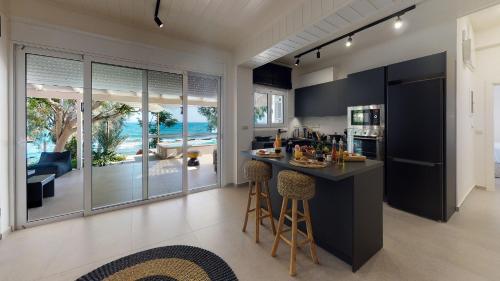 a kitchen with black cabinets and a island with bar stools at Nikkon Luxury Living in Arvi