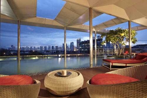 a patio area with chairs, tables and umbrellas at Morrissey Hotel Residences in Jakarta