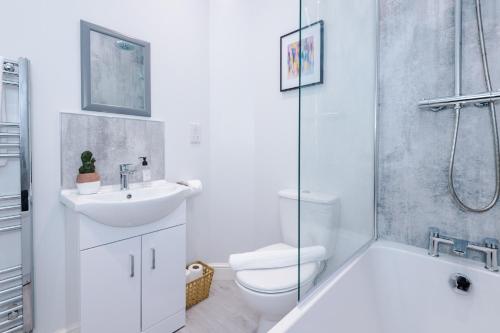 La salle de bains est pourvue d'un lavabo, de toilettes et d'une douche. dans l'établissement Beechwood Lodge Serviced Apartment, à Coventry