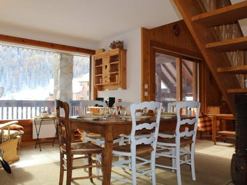 une salle à manger avec une table et des chaises en bois dans l'établissement Appartement cosy 6 pers avec mezzanine et garage à Vars - FR-1-330B-162, à Vars