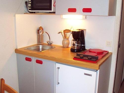 une petite cuisine avec un évier et un micro-ondes dans l'établissement Appartement Vars Ste Marie - 2P+coin montagne, 4 couchages, balcon Ouest, proche pistes - FR-1-330B-167, à Vars
