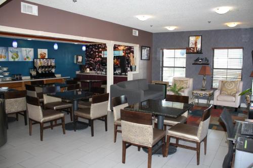 a restaurant with tables and chairs and a bar at Executive Inn and Suites Wichita Falls in Wichita Falls
