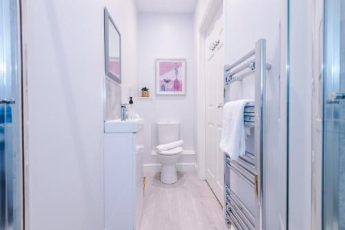 Baño blanco con aseo y lavamanos en Hearsall Place Serviced Apartment en Coventry