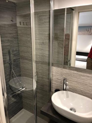 une salle de bain avec une douche en verre et un lavabo dans l'établissement Monaco Beausoleil 