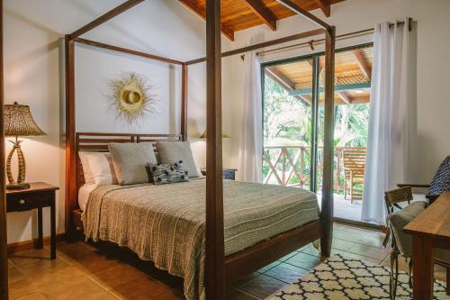Schlafzimmer mit Himmelbett und Balkon in der Unterkunft Beach Heaven in Playa Guiones