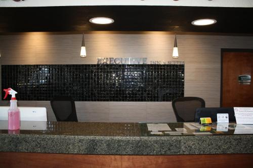 a bar in a restaurant with a pink bottle on a counter at Executive Inn and Suites Wichita Falls in Wichita Falls