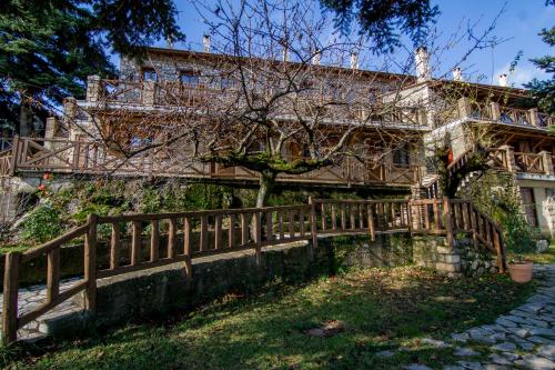 a wooden fence in front of a building at Pigi Tarlampa Hotel in Ano Trikala