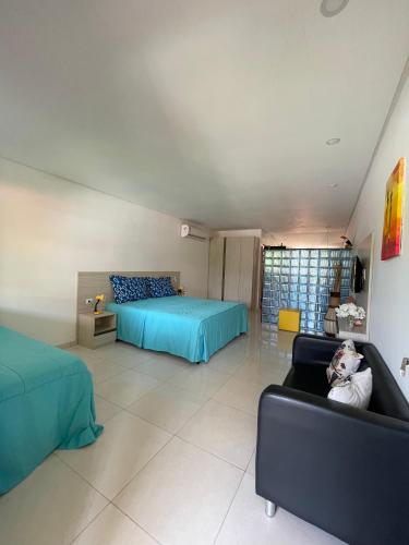 a living room with two beds and a cat laying on a couch at Condomínio Oasis das Flores in Porto De Galinhas
