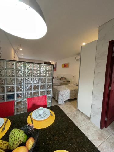 a kitchen with a table and a room with a bedroom at Condomínio Oasis das Flores in Porto De Galinhas