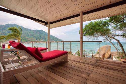 a deck with a chair and a table and the ocean at Crystal Bay Yacht Club Beach Resort in Lamai