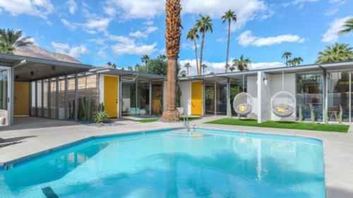 a swimming pool in front of a house at Limon Palm Springs A Luxury Boutique Hotel in Palm Springs