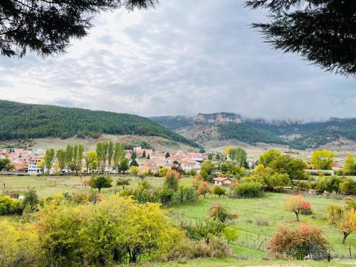 a small town in a field with trees and mountains at Alojamiento Rural Los Hacheros in Tragacete
