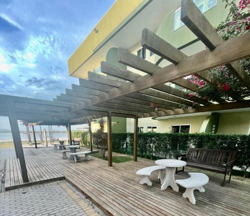 a wooden deck with benches and tables on a building at Arraial do Cabo - Condomínio com cara de Resort in Arraial do Cabo