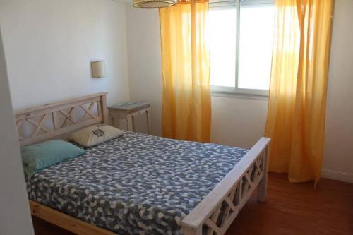 1 dormitorio con 1 cama y una ventana con cortinas de color naranja en Petit depto en mar del plata en Mar del Plata