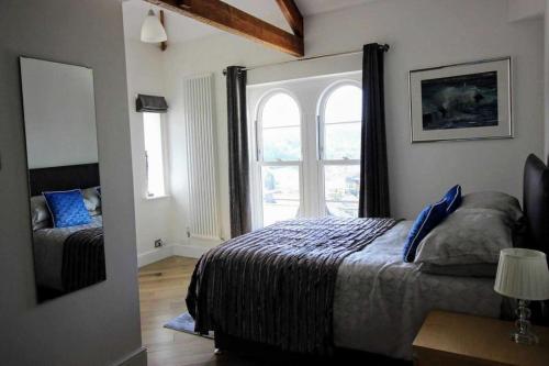 sypialnia z łóżkiem i oknem w obiekcie Boutique Apartment Brixham w mieście Brixham