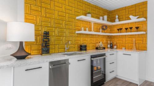 a kitchen with white cabinets and a yellow wall at Limon Palm Springs A Luxury Boutique Hotel in Palm Springs