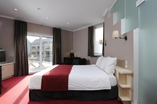 a hotel room with a bed and a balcony at Hotel Astoria Gent in Ghent
