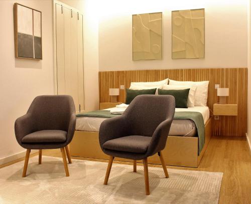 1 dormitorio con 1 cama con 2 sillas en Oporto Prime Studios, en Oporto