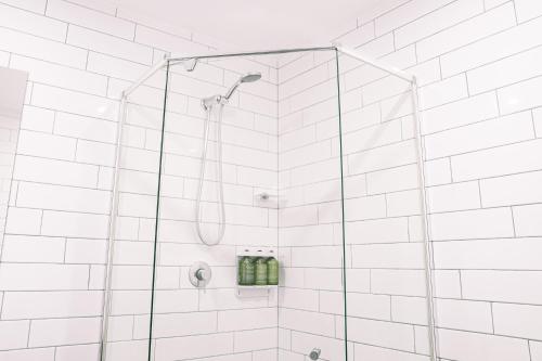 a bathroom with a shower with white tiles at Drifter Byron Bay in Byron Bay